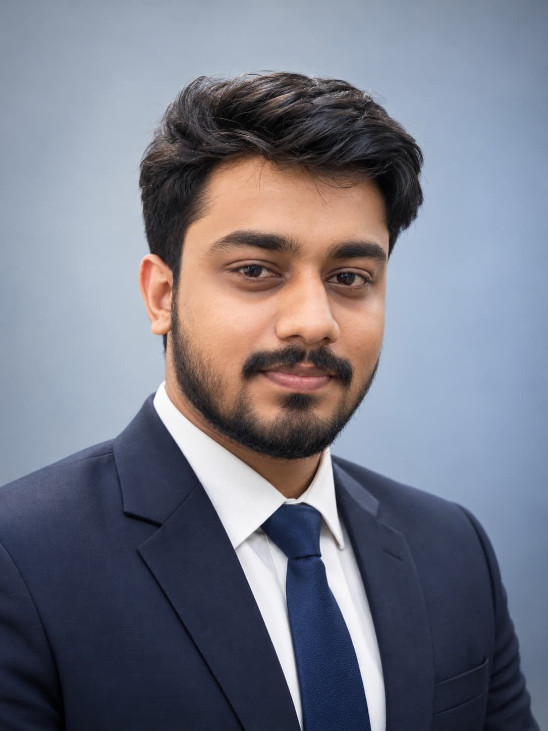 Abhijith J D in a navy suit and tie, studio headshot